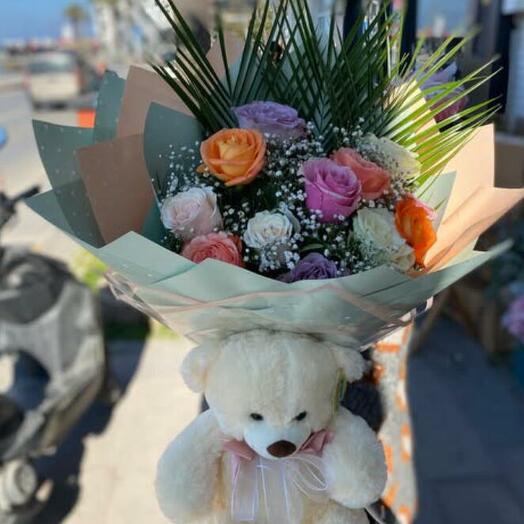 Bouquet of colorful roses and a teddy bear