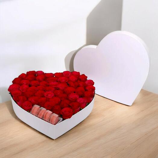 Red roses and a macaron in a white heart box