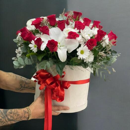 Buyuk kutu içinde kırmızı guller ve lilyum papatyalar